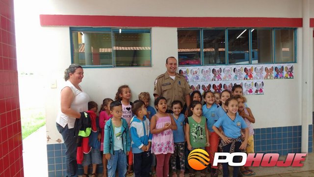 Cabo Renys Cambraia ladeado pelos alunos e professora Heloisa (Foto: Divulgação PolÃcia Militar)